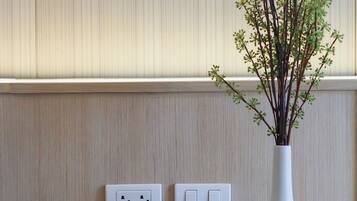 A reception desk with a magazine, a vase with branches, and a wall-mounted light fixture.