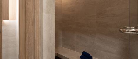 Ein modernes Duschbad mit Sitzbank und Handtuch.
