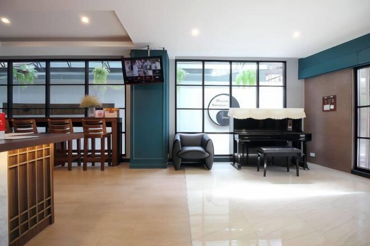 Une pièce spacieuse avec un piano, un coin bar et de grandes fenêtres.