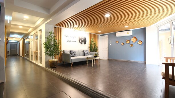 A spacious lobby with a wooden slatted ceiling, a reception desk, a sofa, and a coffee table. - Super OYO 483 Pannee Hotel Khaosan (Bangkok)