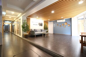 A spacious lobby with a wooden slatted ceiling, a reception desk, a sofa, and a coffee table. - Super OYO 483 Pannee Hotel Khaosan (Bangkok)