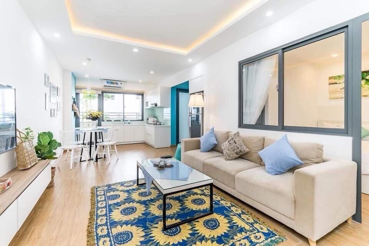 A modern living room with a sofa, coffee table, and a large window.