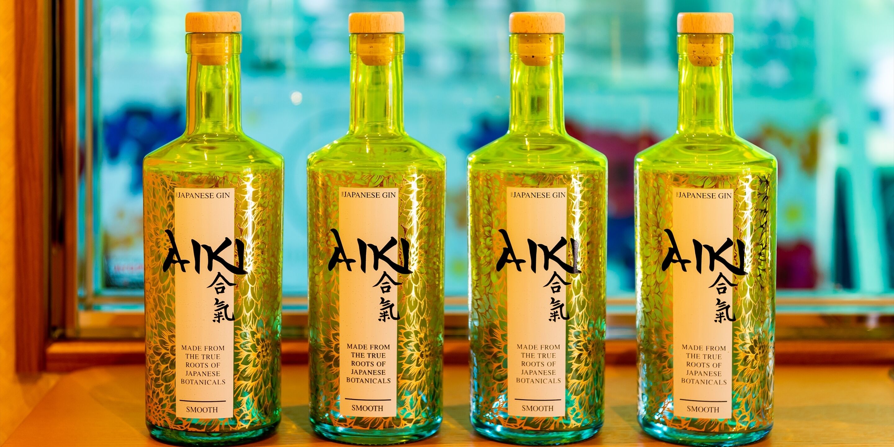 Four bottles of Japanese gin with labels, placed on a wooden surface.