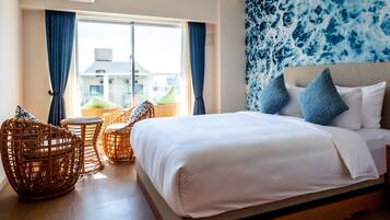 A bedroom with a bed, wicker chairs, a nightstand, and a wall mural.