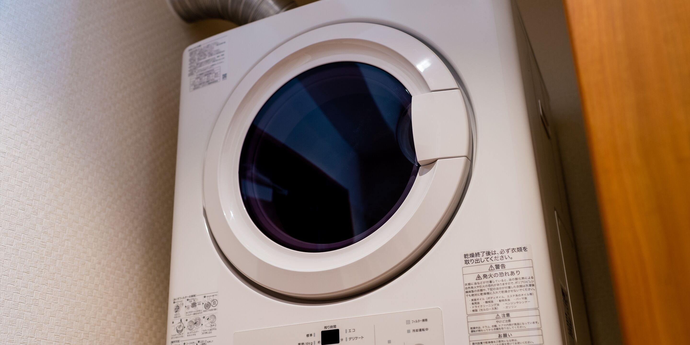 A front view of a washing machine with a control panel and instruction manual.