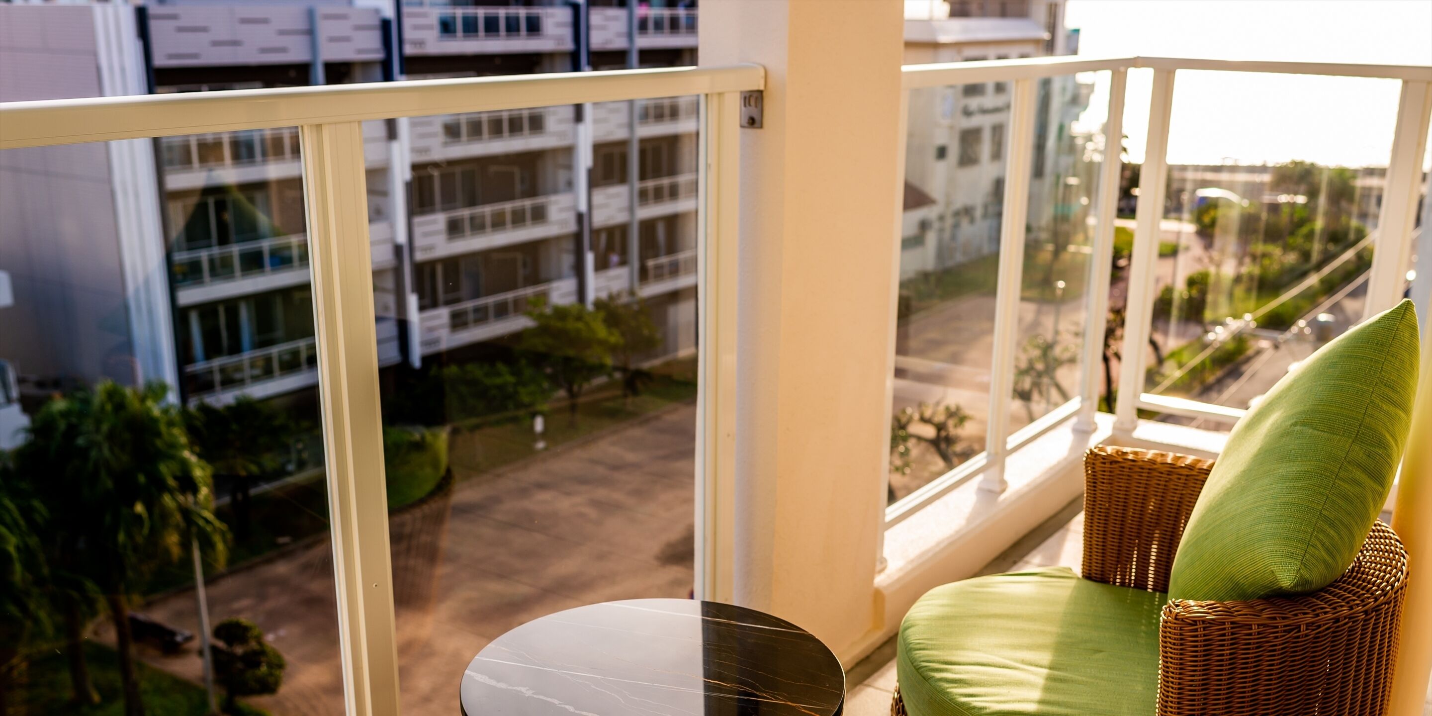 Un balcón con mobiliario de mimbre y vistas a la ciudad.