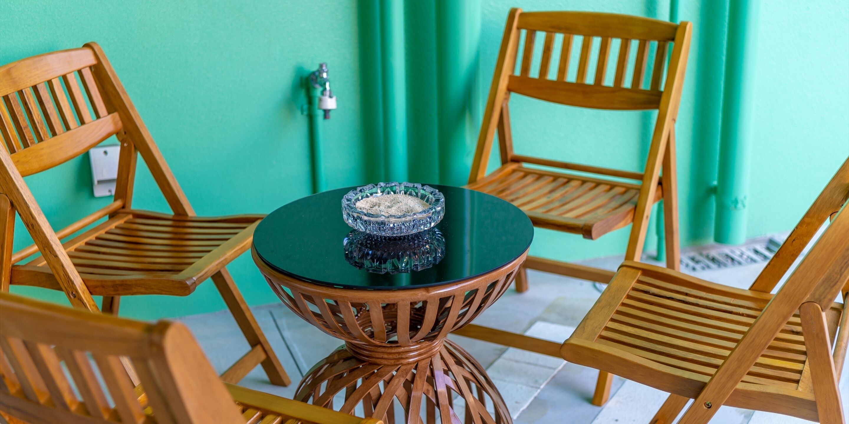 A round table with a glass bowl in the center, surrounded by wooden chairs.