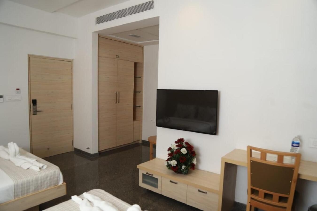Una habitación de hotel con cama, escritorio, televisor, armario y baño.