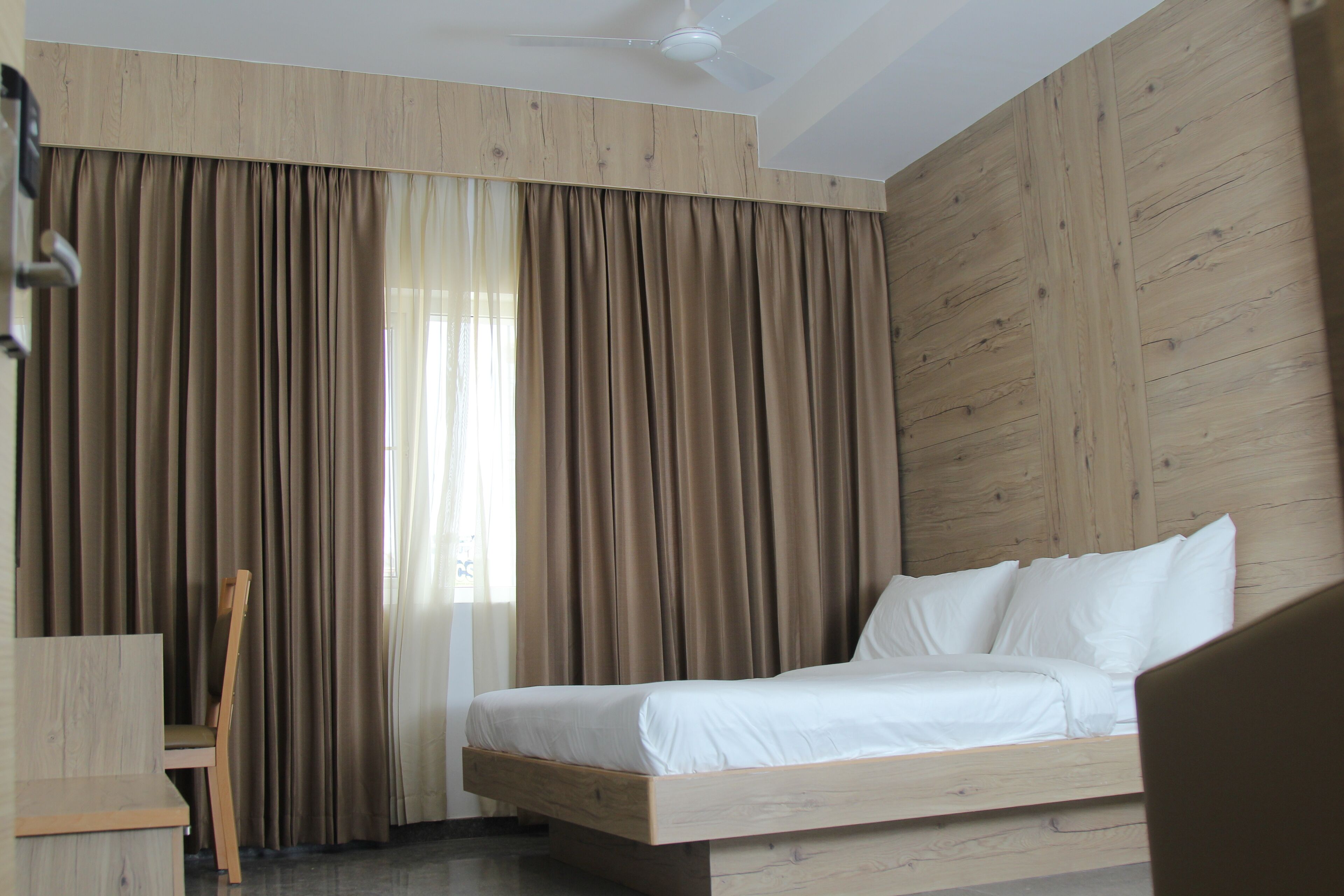 A bedroom with a bed, a chair, and a desk.