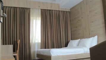 A bedroom with a bed, a chair, and a desk.