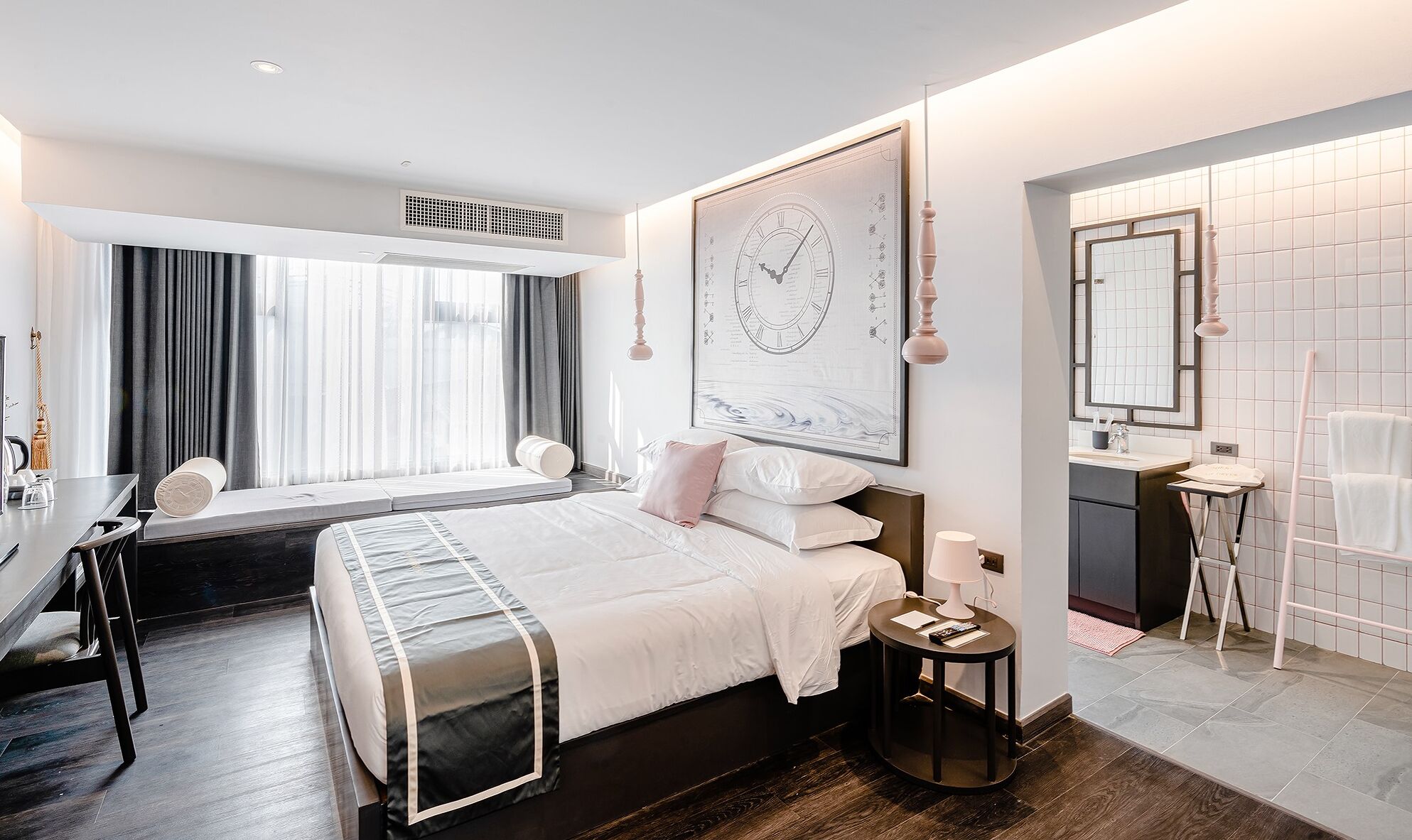 Una habitación de hotel moderna con una cama grande, un escritorio y un baño.