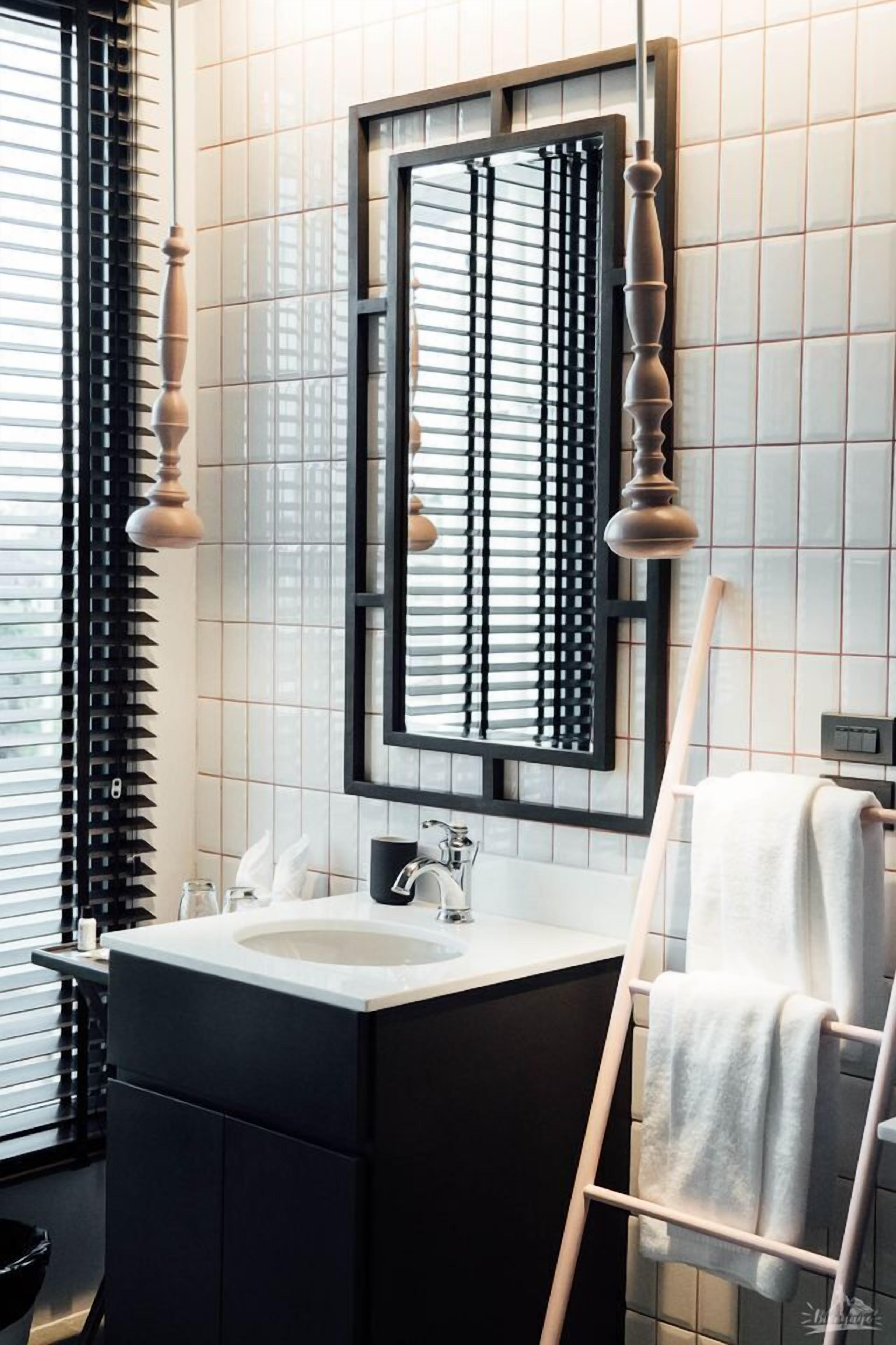 Een moderne badkamer met een grote spiegel, een wastafel en een handdoekrek.