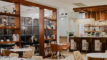 Un café acogedor con estanterías de madera, asientos cómodos y una zona de bar.