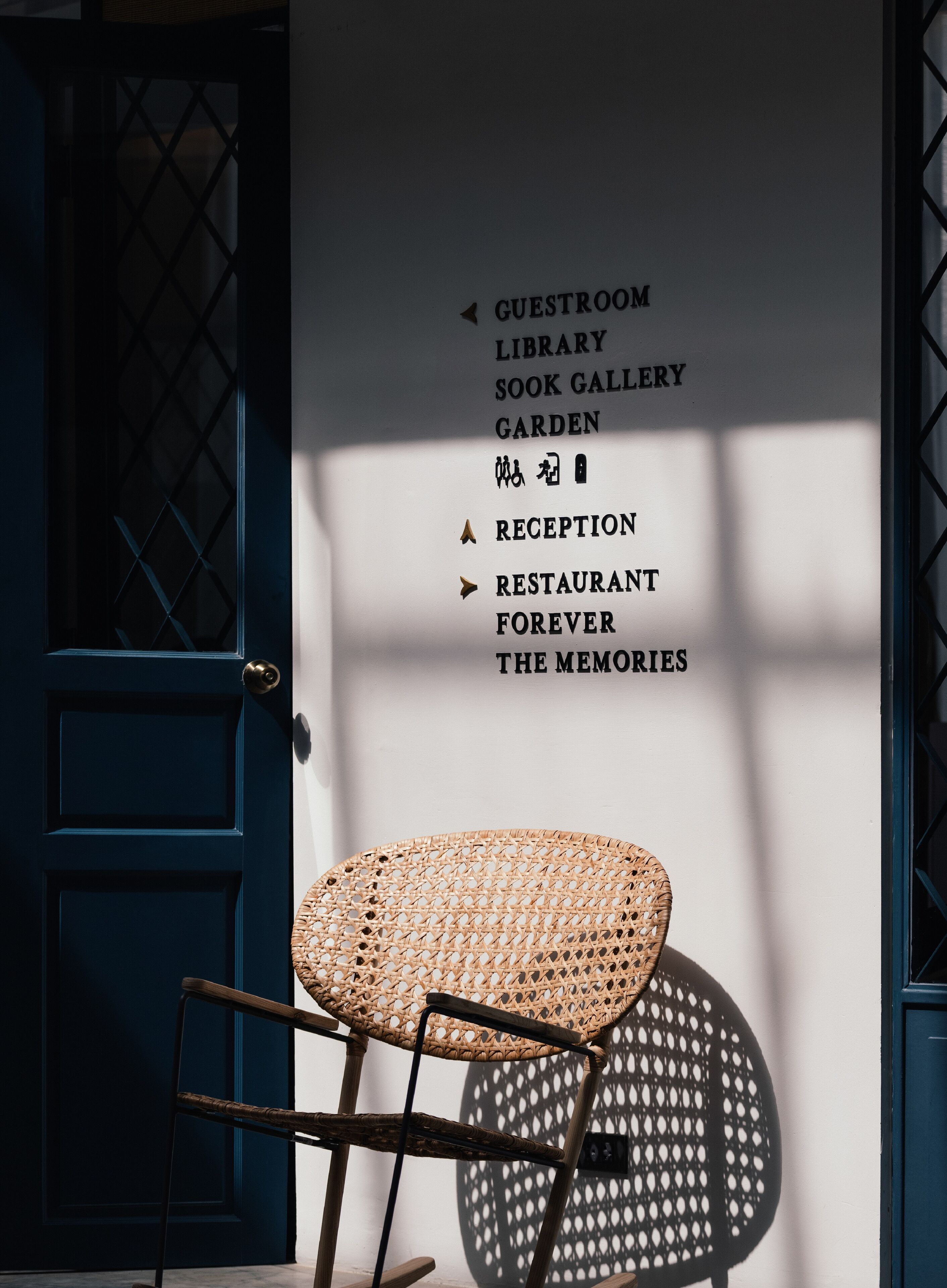 A sign listing amenities including a guestroom, library, sook gallery, garden, reception, restaurant, and the memories.