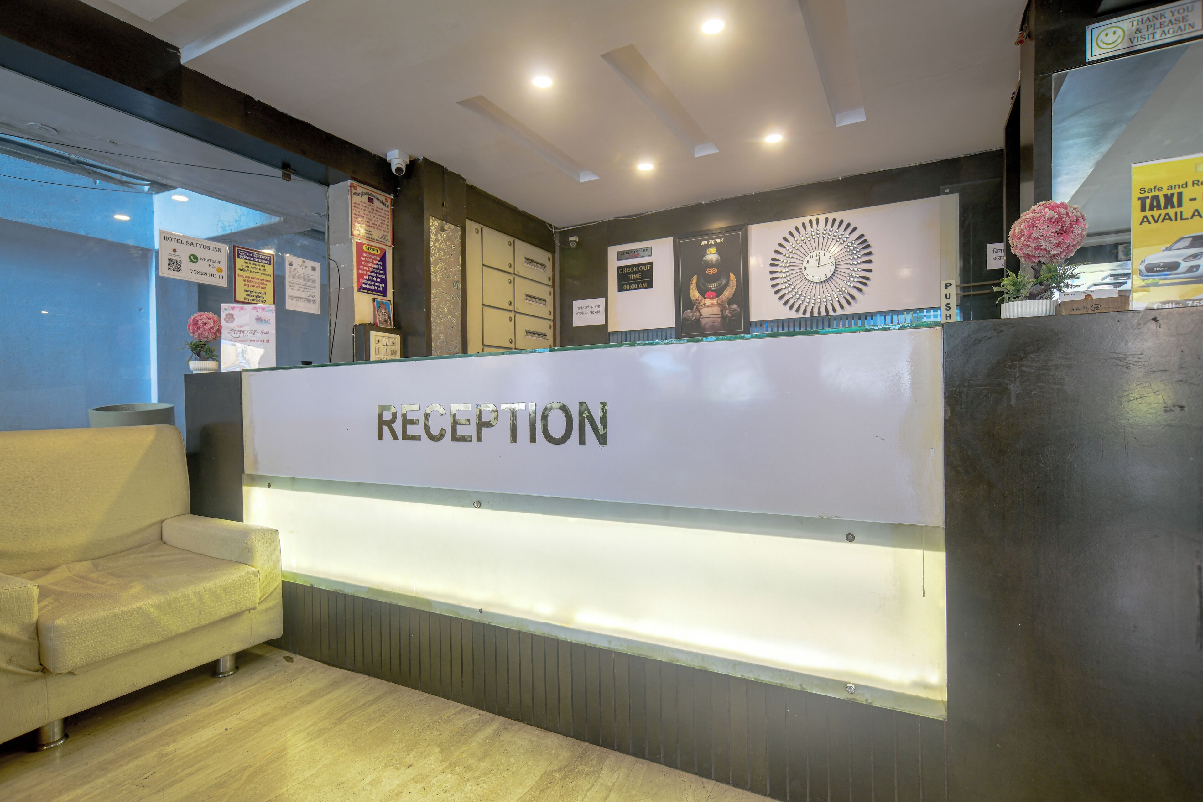 A reception area with a reception desk, a sofa, and various informational posters on the wall.