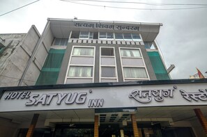 A hotel named SATYUG INN with a sign in both English and Hindi.