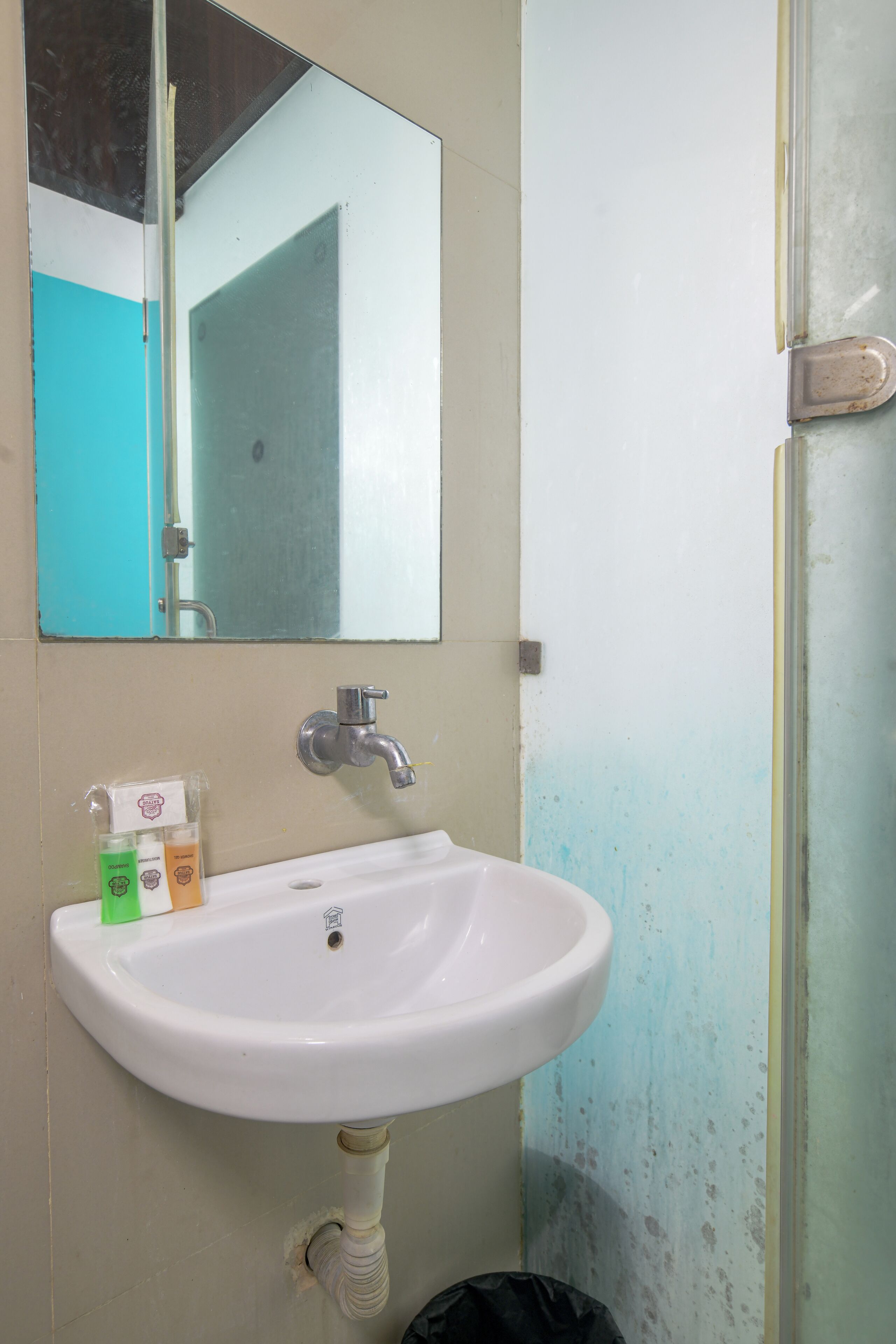 Ein Badezimmer mit Waschbecken, Spiegel und Duschabtrennung.