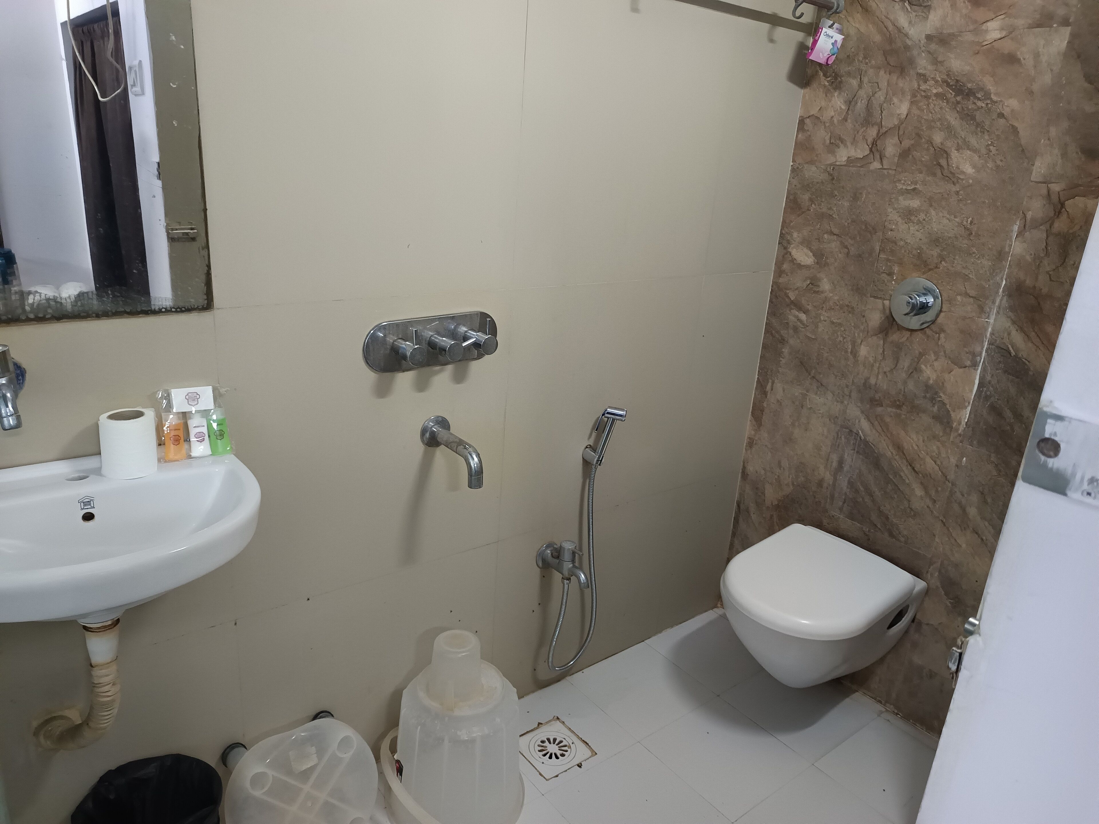 A bathroom with a sink, toilet, shower, and a mirror.