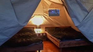 A tent with two beds, a window, and a table lamp. - Saros Tepe Camping (Gallipoli)