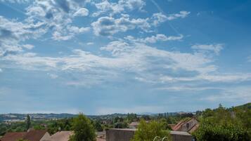 Un paysage rural avec des maisons, des arbres et un ciel dégagé.