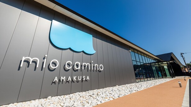 A modern building with a large sign reading "mio camino AMAKUSA". - Seacruise House Navio (Kamiamakusa)
