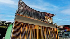 A building with a curved roof, large windows, and a gated entrance. - Hotel O Surabaya near Surabaya Town Square formerly Kupang Gunung Residence (Surabaya)