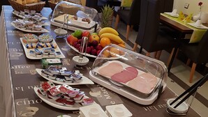 A buffet table with various food items including fruits, pastries, and dairy products. - Hotel Villa Lalee (Dresden)