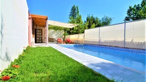 Una piscina al aire libre, sombrillas, tumbonas