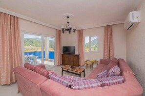 Villa | Woonkamer | Een flatscreentelevisie en een open haard