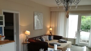 A dining area with a table set for four, a sofa, and a chandelier. - Haus Grünewald Unsleben (Unsleben)