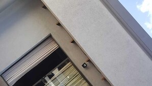 A building corner with a window, a light fixture, and a brick pavement. - Botle Ba Afrika Lodge (Vereeniging)