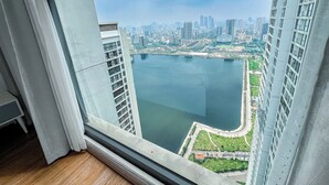 Un edificio alto con vista a una gran masa de agua y un paisaje urbano al fondo.