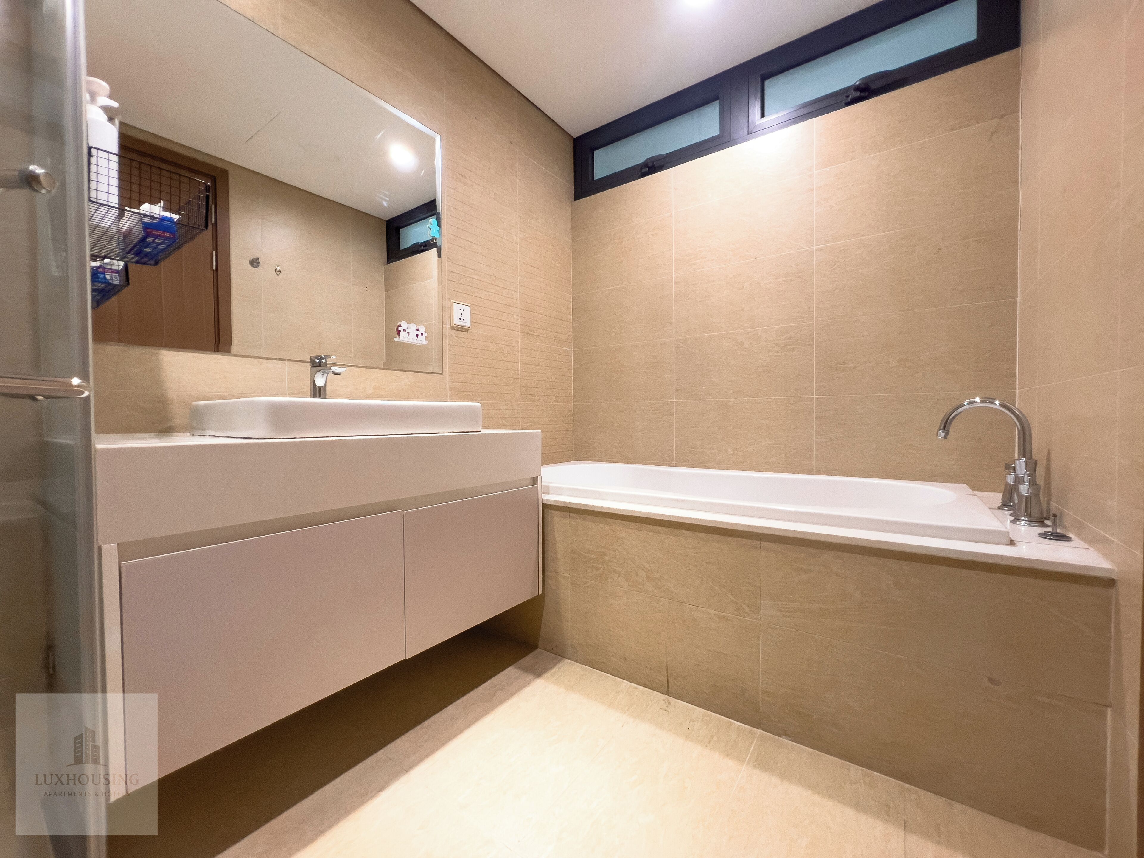 A modern bathroom with a double sink vanity, a large mirror, and a standalone bathtub.