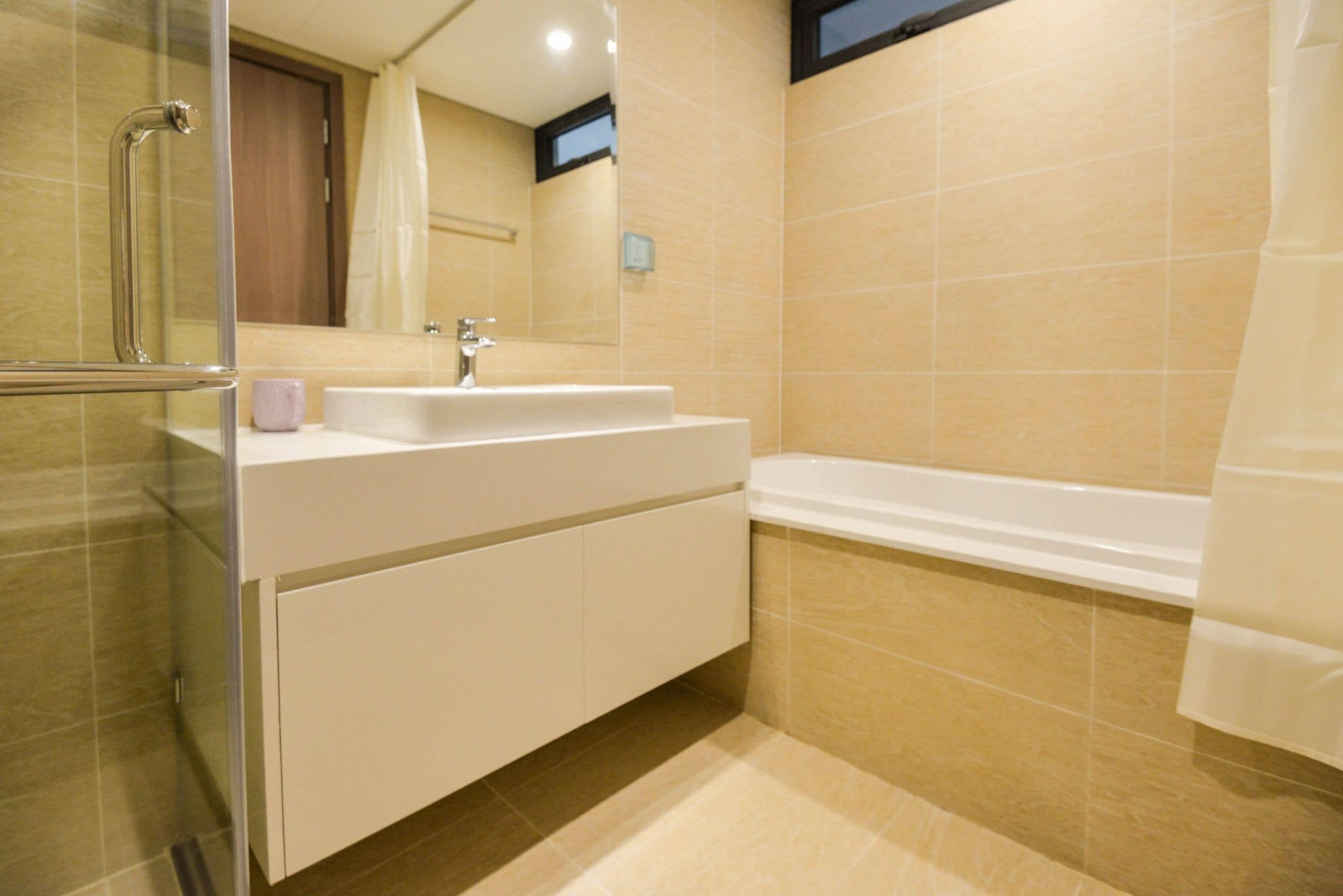 A bathroom with a glass shower enclosure, a white sink, and a bathtub.