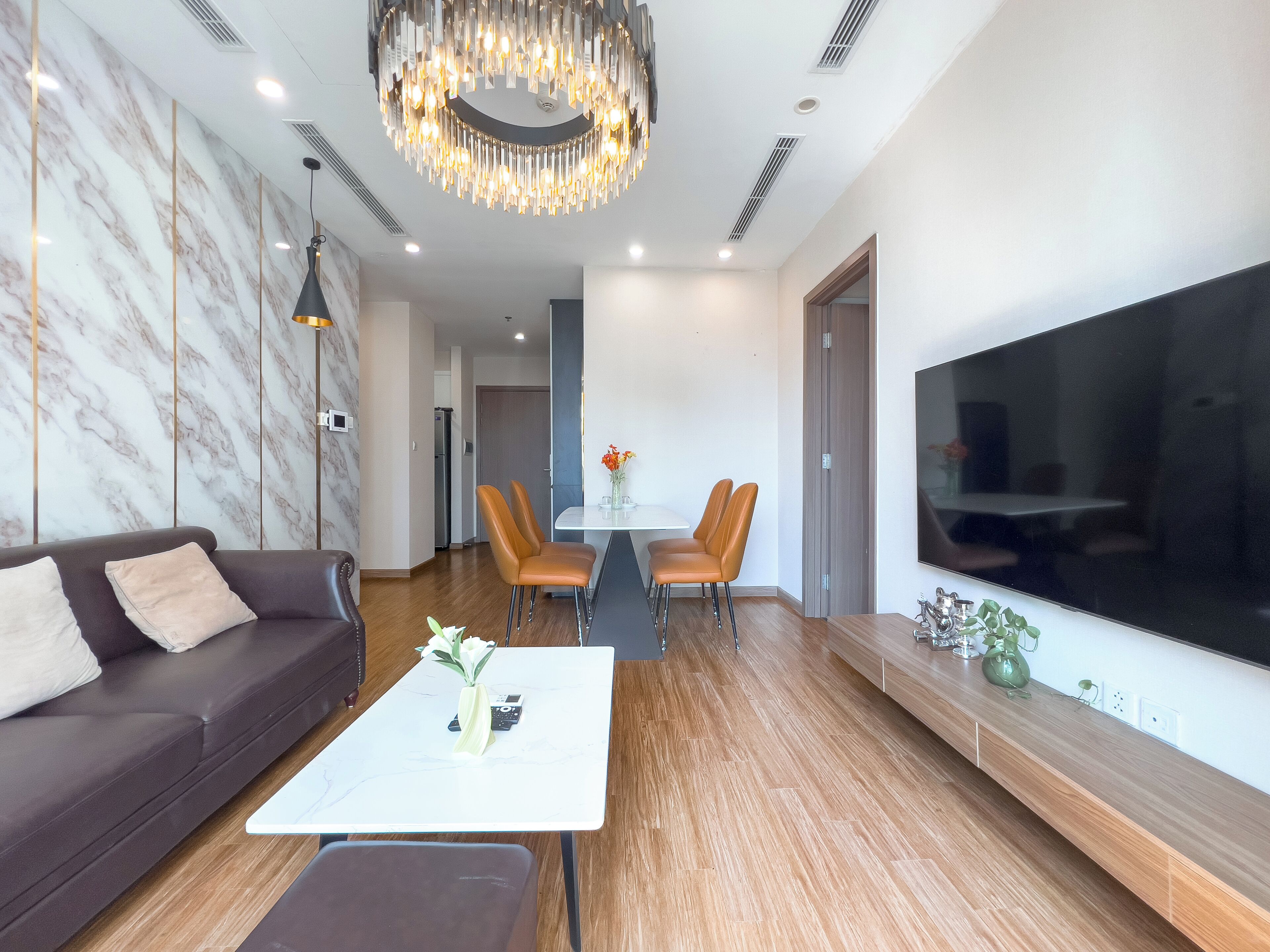 A modern living room with a sofa, coffee table, and dining area.