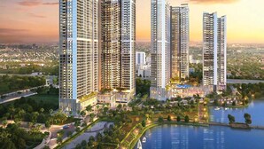Un complejo residencial de edificios de gran altura con varias torres, una zona ajardinada central y una masa de agua.