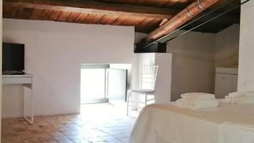 A room with a bed, a desk, and a television.