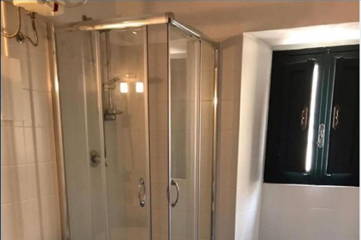 Un baño con ducha de vidrio, inodoro y lavamanos.