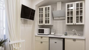 A compact kitchen with white cabinets, a microwave, a coffee maker, and a dishwasher. - Apart Hotel Quartet (Odesa)