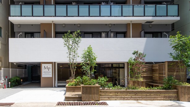 A modern hotel with a two-story structure, outdoor wooden planters, and a sign indicating it is a hotel. - MP HOTELS Nagasaki Mizubenomori (Nagasaki)