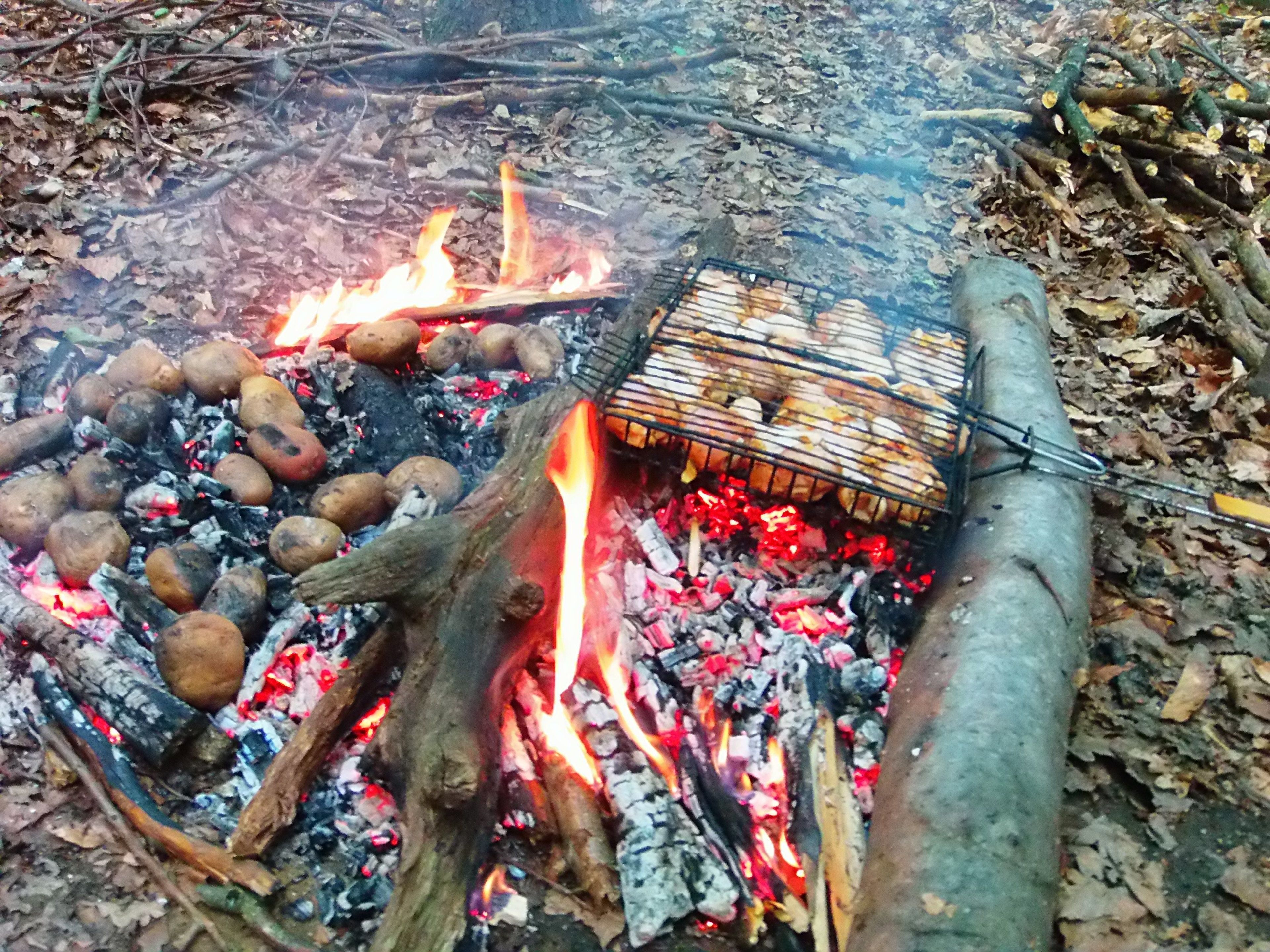 Foc de camp amb una graella i patates.