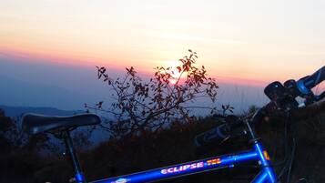 A bicycle with a blue frame and the word "Eclipse" on it, parked outdoors with a sunset in the background.