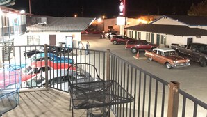 Un parking avec plusieurs voitures et un bâtiment sur lequel on peut voir une enseigne.