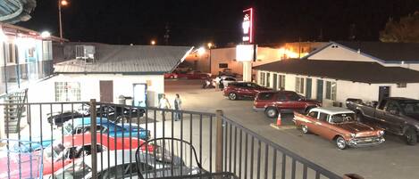 A parking lot with several cars and a building with a sign.