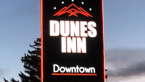A neon sign for Dunes Inn Downtown with a mountain and star design.