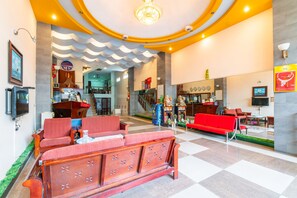 A hotel lobby with a checkered floor, a red sofa, a wooden reception desk, and a staircase leading to an upper level. - Super OYO 266 Golden Gate (Da Nang)