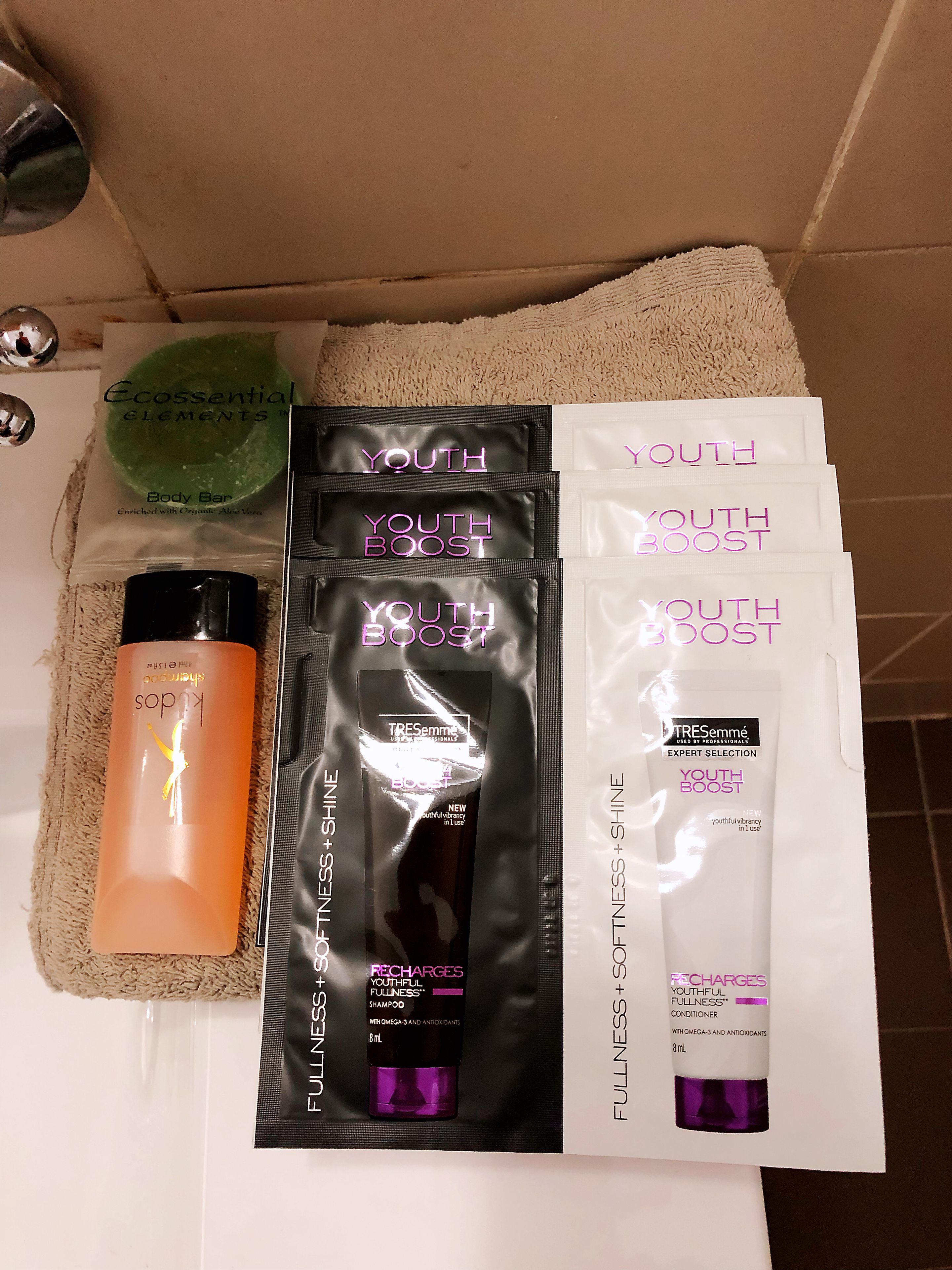 Un baño con artículos de aseo personal, incluyendo jabón corporal, revitalizante y champú.