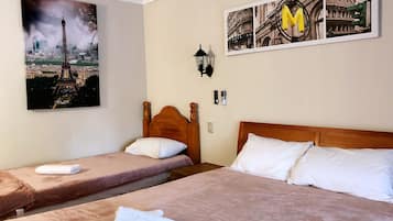 Une chambre d’hôtel avec deux lits, une grande photographie représentant un paysage urbain accrochée au mur et un tableau encadré représentant un bâtiment historique.