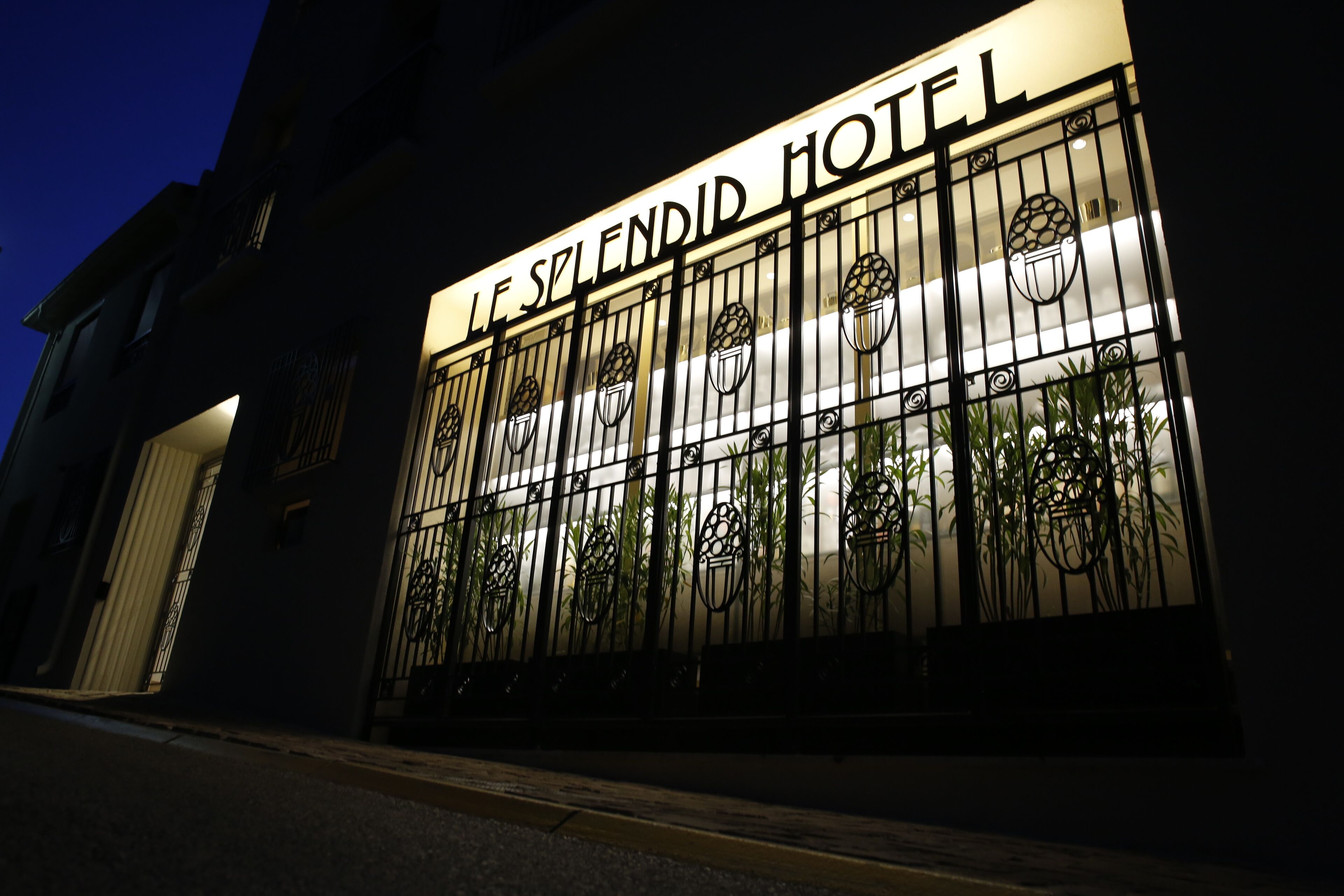 A hotel entrance with a metal gate and a sign that reads "LE SPLENDID HOTEL."
