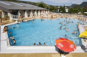 A large indoor swimming pool with multiple lanes, a diving board, and a lifeguard stand. - Village de Gites le Colombier (Mende)